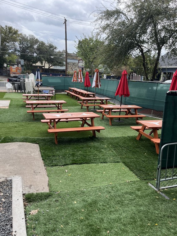 Empty Longhorn picnic tables set up on the patio turf