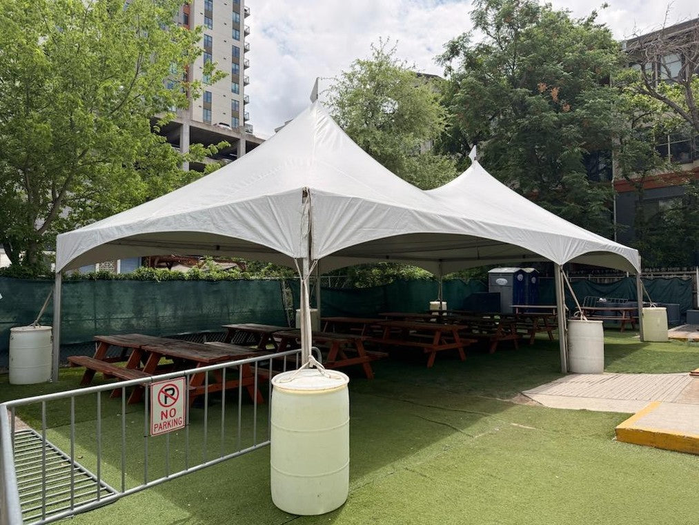 An event tent set up over picnic tables for a private party
